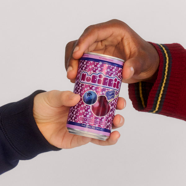Two hands protectively cupping a purple NoBull Cherry Berry sparkling drink can with bubble pattern design