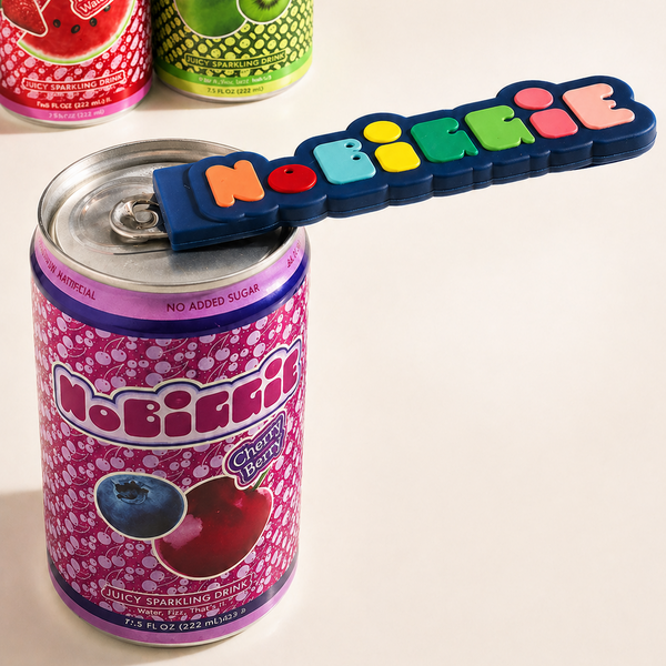 Colorful "NOBRITE" magnetic can opener with multi-colored letters attached to purple cherry-berry flavored sparkling drink can, with additional fruit-flavored cans in background.
