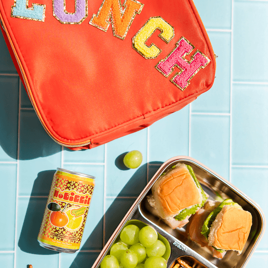 NoBiggie Clementine Lemon kids sparkling drink with a lunch box and packed lunch.